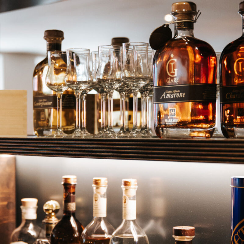 Flaschen und Gläser in einer Bar auf Regal