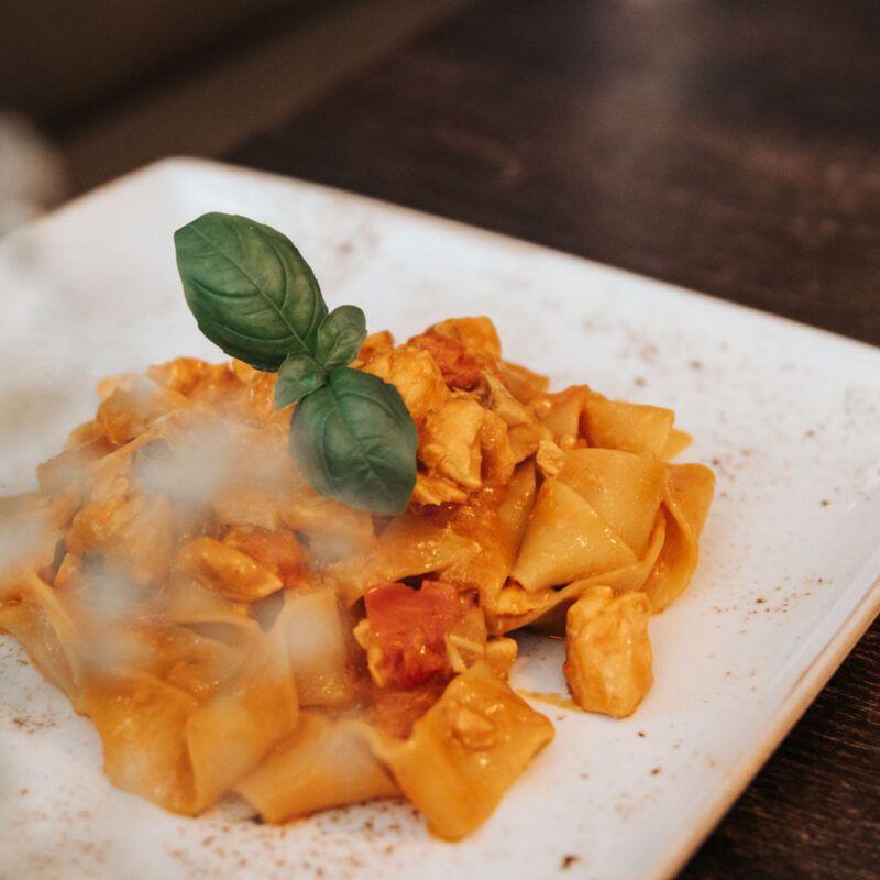 Hausgemachte Pasta mit Tomatensauce und Basilikumblättern